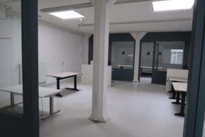 Lichte, lege kantoorruimte aan het Gedempt Hamerkanaal met meerdere bureaus en glazen vergaderruimtes.